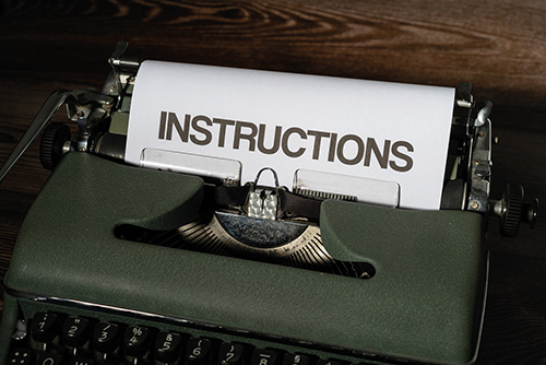 Schreibmaschine mit einem Blatt Papier mit der Aufschrift "Instructions"
